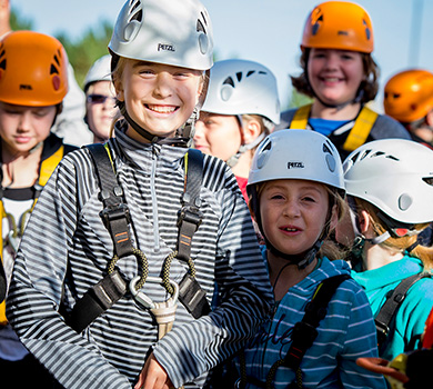 students smiling on a ropes course at the Blue Mountain resort in Collingwood Ontario